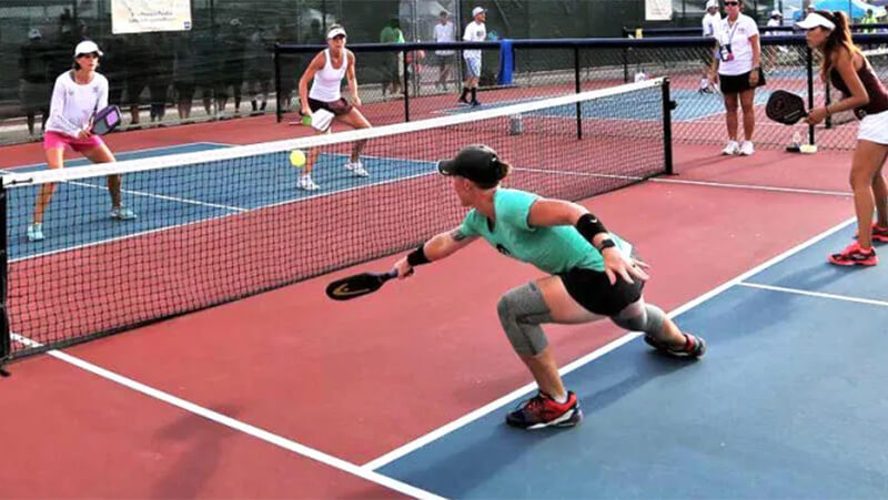 People playing pickleball on a court learning to dink.